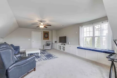 a living room with furniture a large window and a chandelier