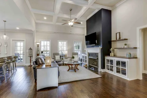 a living room with furniture kitchen view and a chandelier