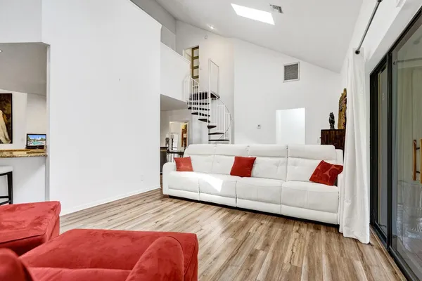 a living room with furniture and a wooden floor