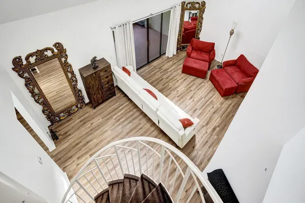 a view of a hallway with wooden floor and a dining room