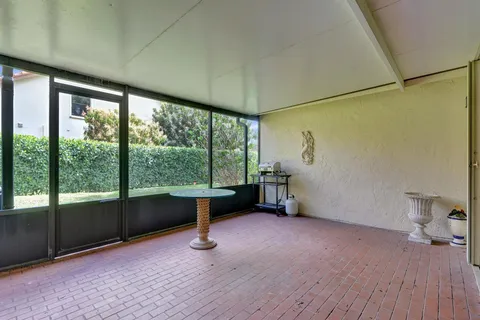 a view of a swimming pool with lawn chairs and a yard