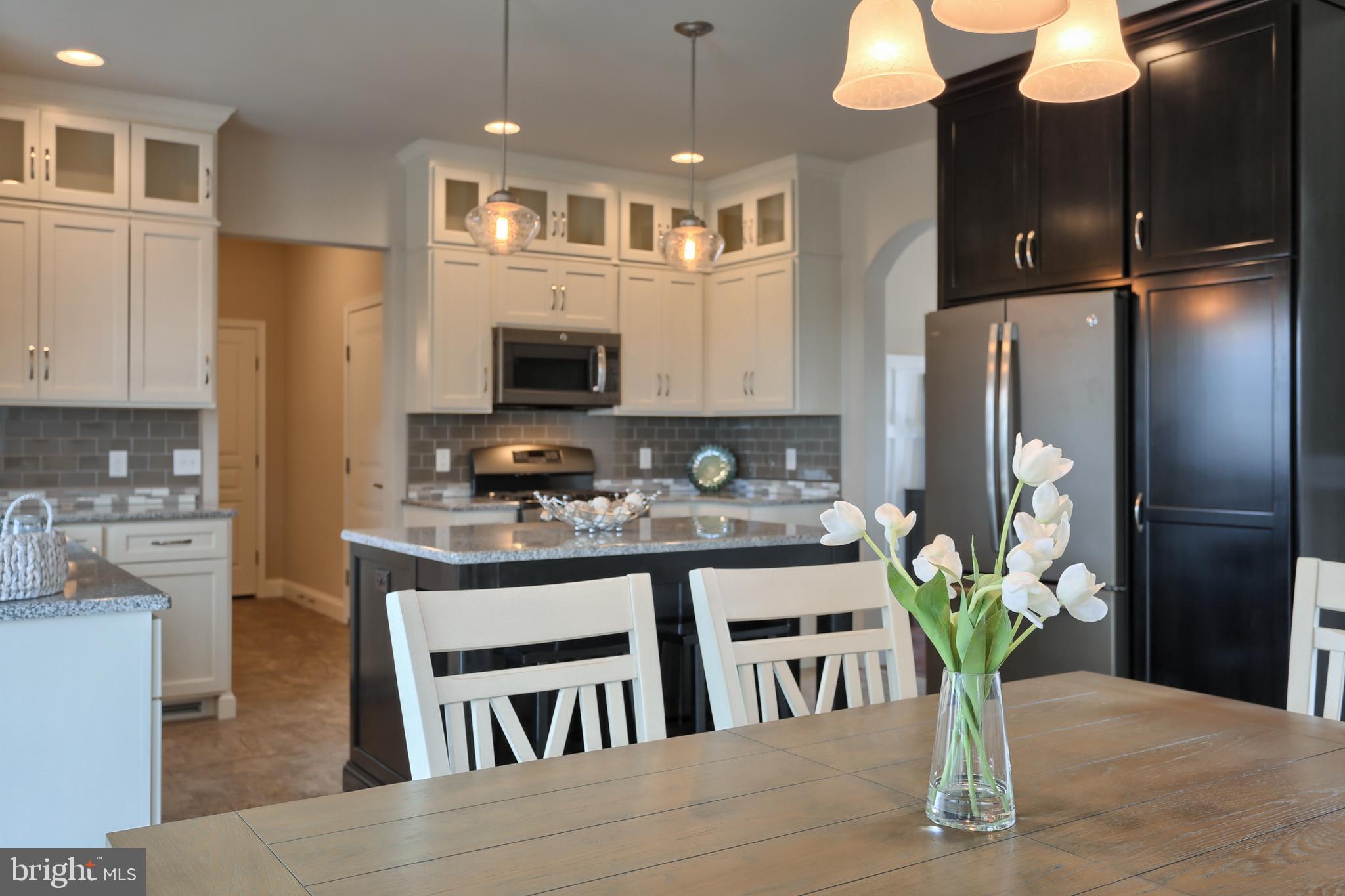 5 Rolling Meadow Road Lebanon, PA 17046 - Photo 3 of 35 a kitchen with stainless steel appliances granite countertop a refrigerator a stove a sink dishwasher and a dining table with wooden floor