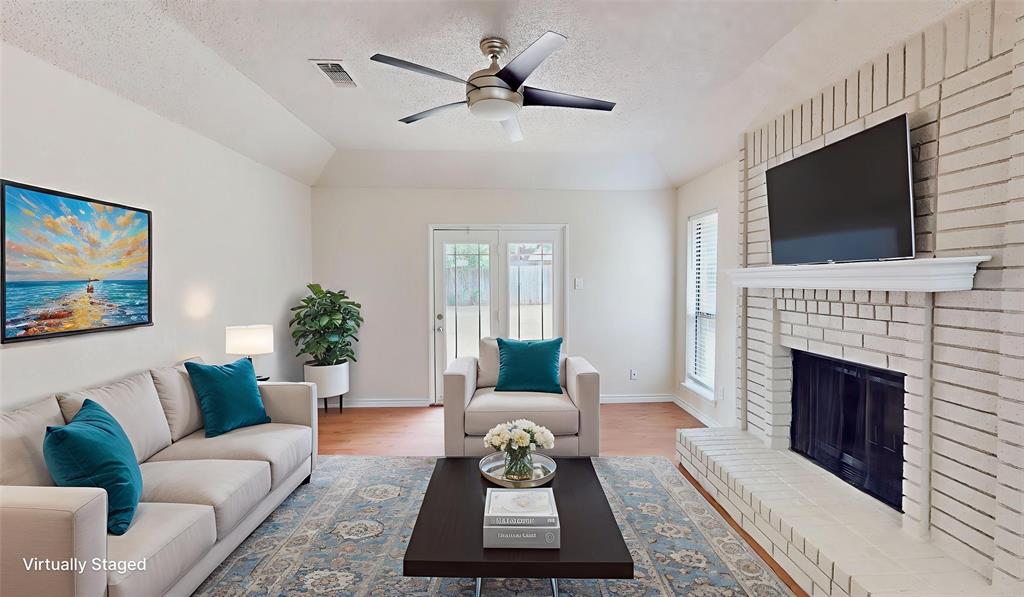a living room with furniture a flat screen tv and a fireplace