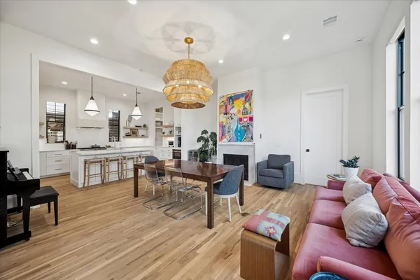 a living room with furniture kitchen view and a chandelier