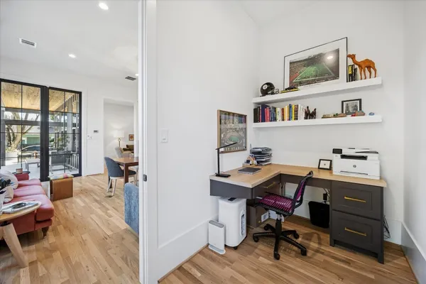 a view of a workspace with furniture and a window