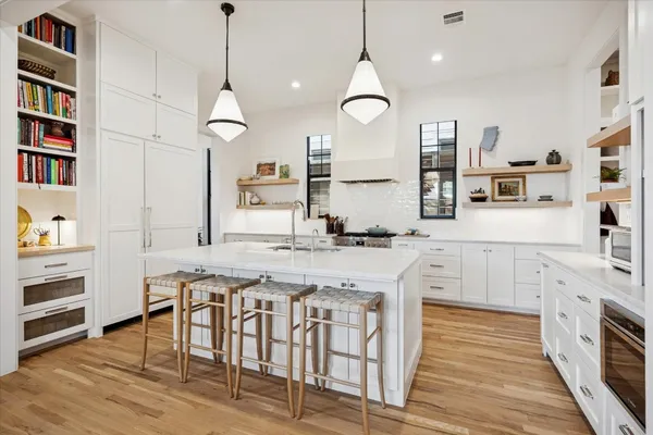 a kitchen with stainless steel appliances granite countertop a stove a sink and a wooden floors