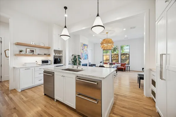 a kitchen with a stove a sink a center island and wooden floor