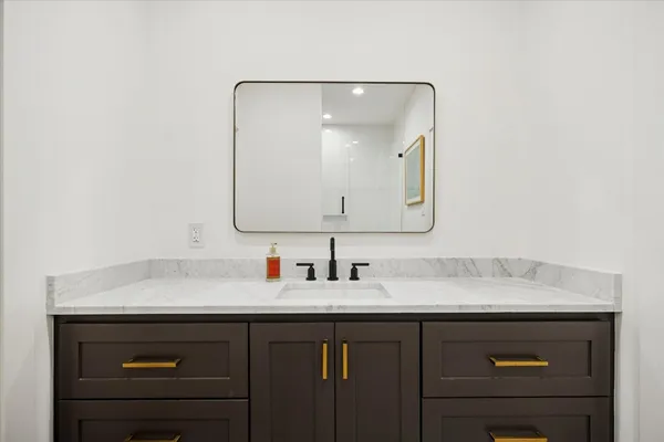 a bathroom with a sink vanity and a mirror