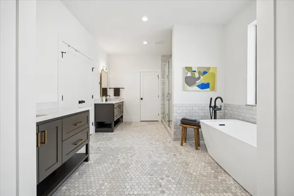 a spacious bathroom with double vanity mirror and tub