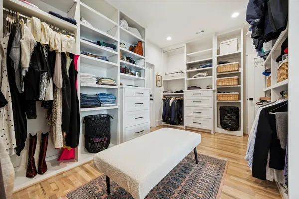 a view of walk in closet with clothes and shoes