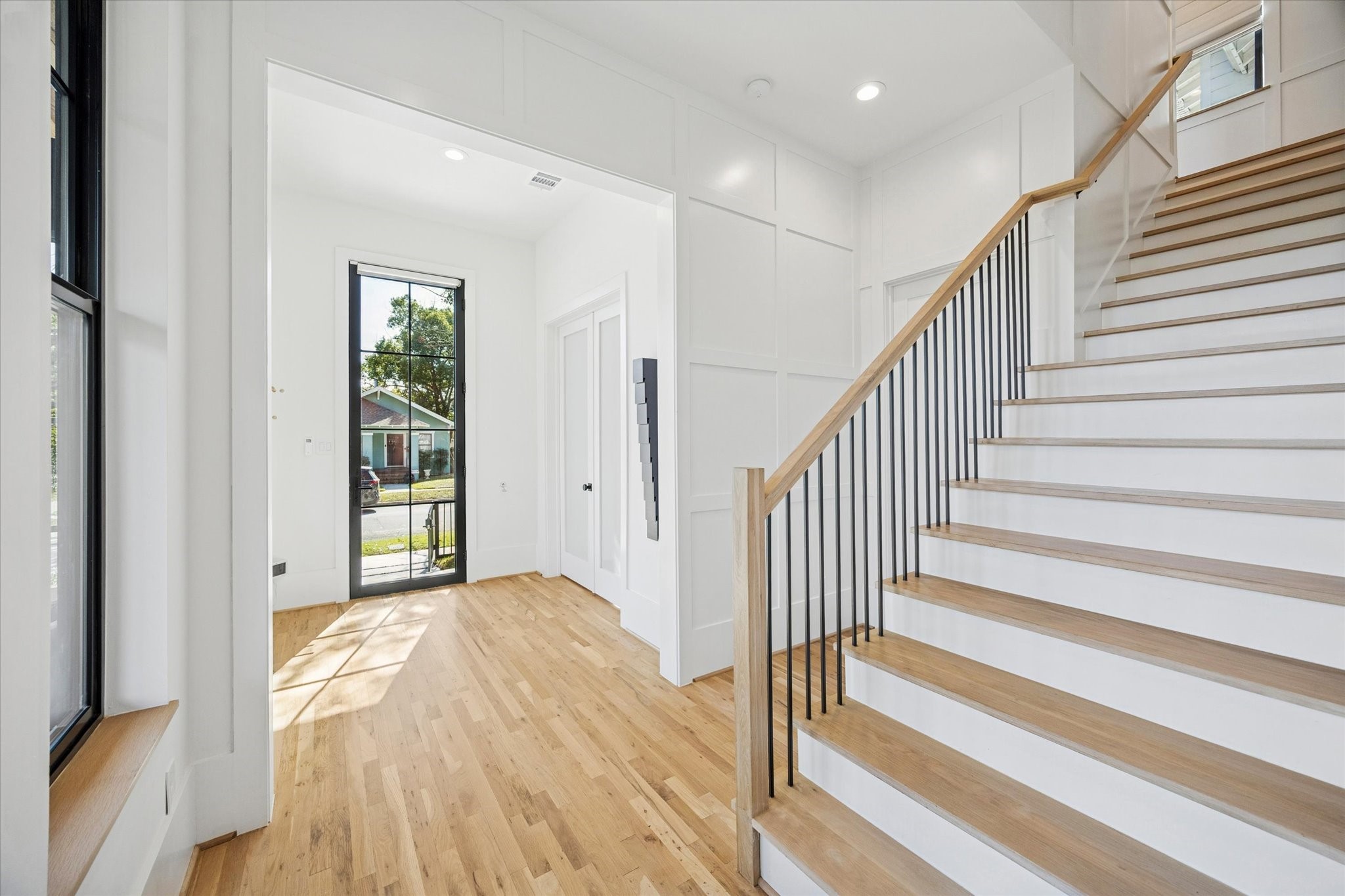 701 Ridge Street Houston, TX 77009 - Photo 4 of 50 An oversized steel front door opens to a sun-drenched entry, highlighted by a dramatic wall of windows.