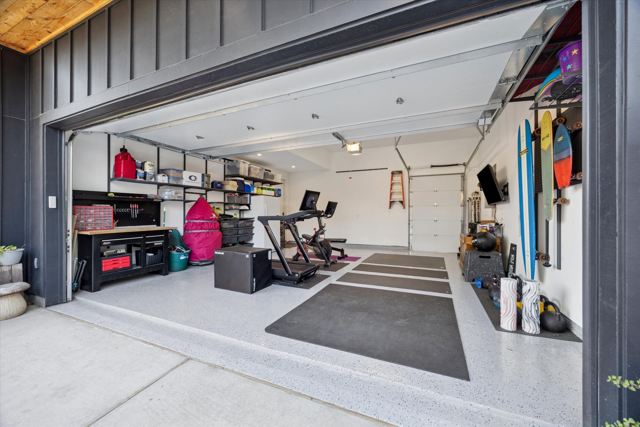 701 Ridge Street Houston, TX 77009 - Photo 44 of 50 Spacious two-car garage with epoxy flooring, currently used as a home gym, plus an additional lift-up door for airflow and patio access.