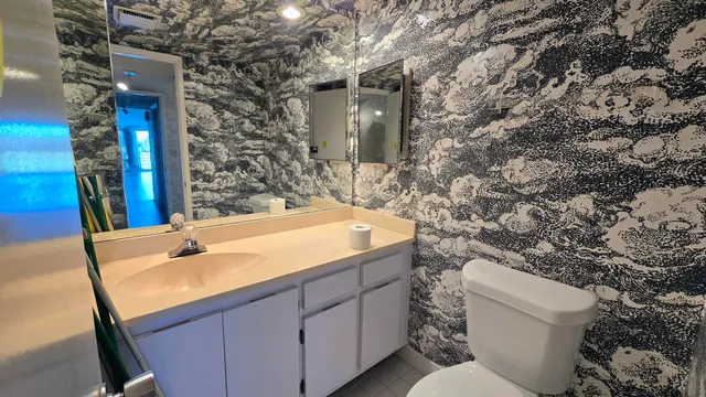 a bathroom with a sink and mirror with toilet
