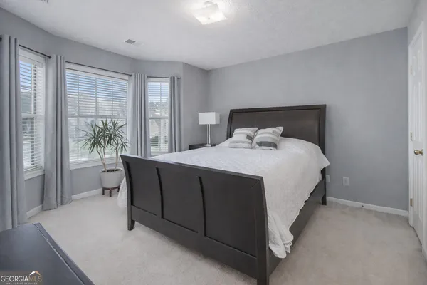 a bedroom with a bed and a large window