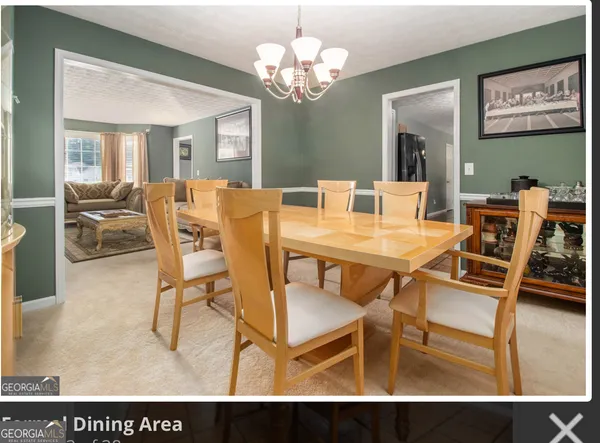a view of a dining room with furniture and a chandelier
