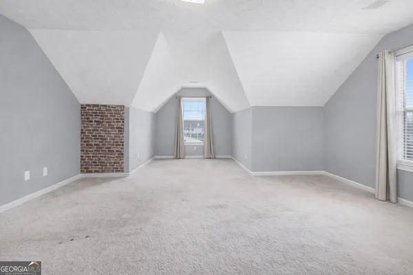 a view of an empty room with a window and fireplace