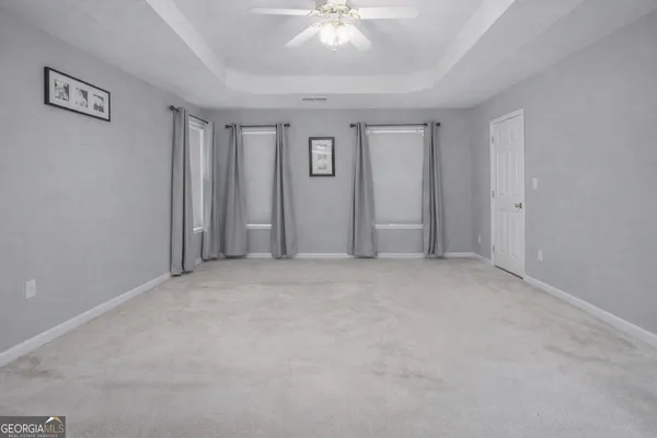 a view of an empty room with a ceiling fan