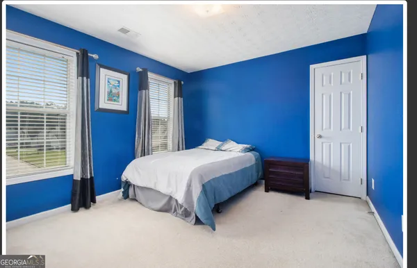 a spacious bedroom with a bed and a window