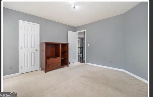a view of an empty room with closet and entryway
