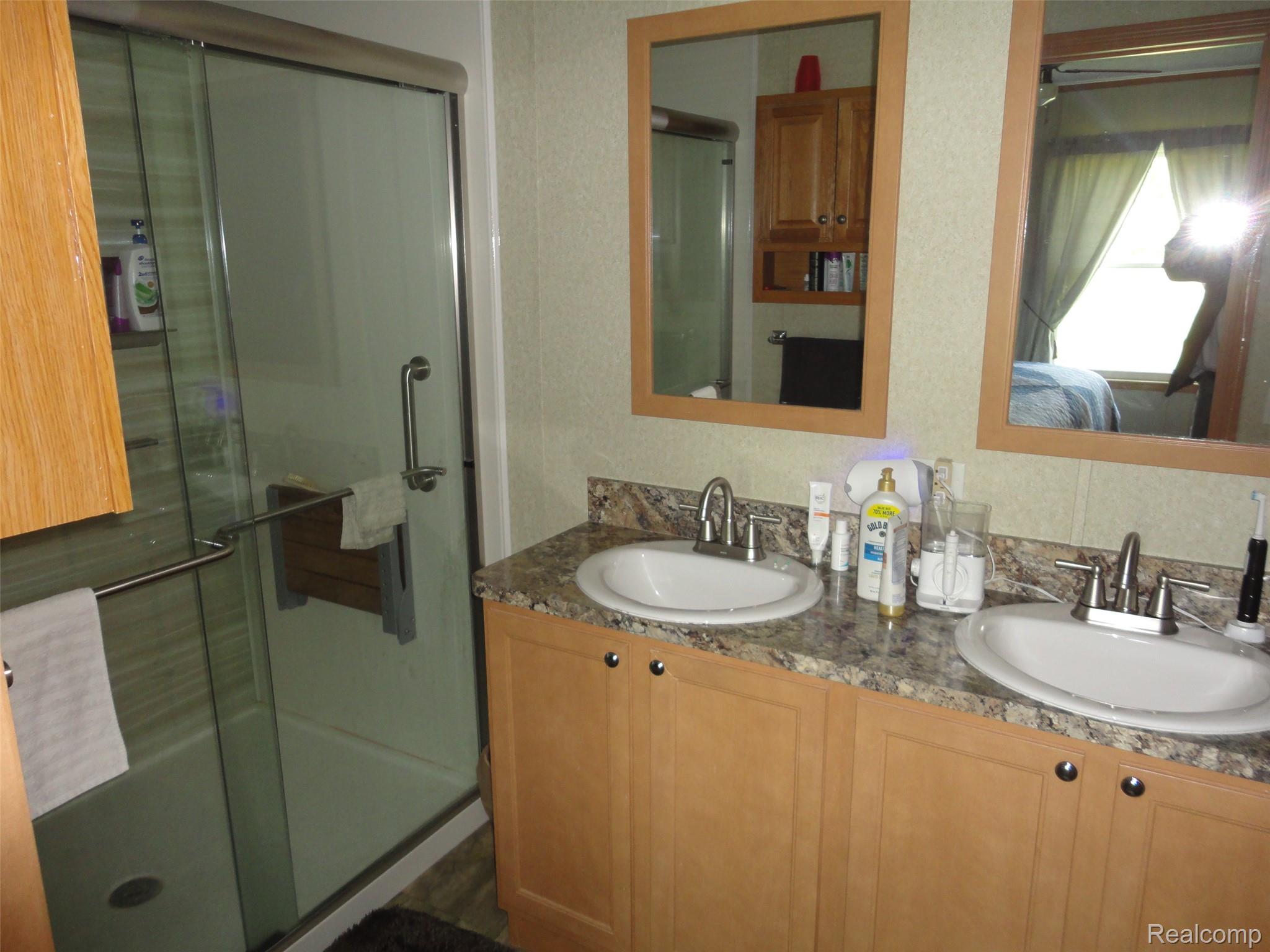 463 Edinborough Temperance, MI 48182 - Photo 9 of 23 Bathroom featuring a dual vanity with undermount sinks, granite-look countertop, and wood-finish cabinetry