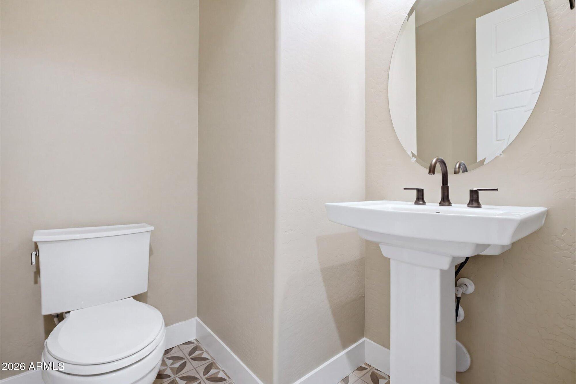 16849 West Merrell Street Goodyear, AZ 85395 - Photo 27 of 35 a bathroom with a toilet sink and mirror