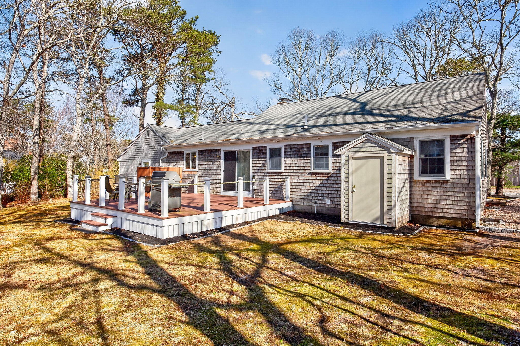 12 Inkberry Lane Harwich, MA 02645 - Photo 30 of 41 a view of a house with a large tree and wooden fence