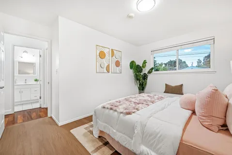 a bedroom with a bed and a painting on the wall