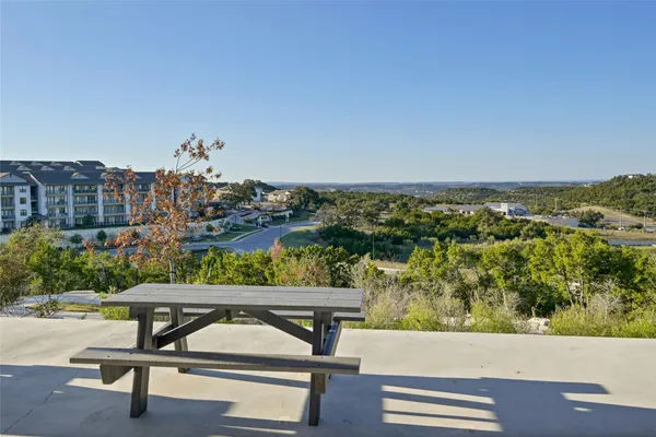 a view of a terrace with a bench and lake view