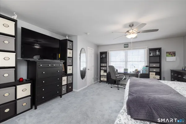 a spacious bedroom with a bed and a chandelier