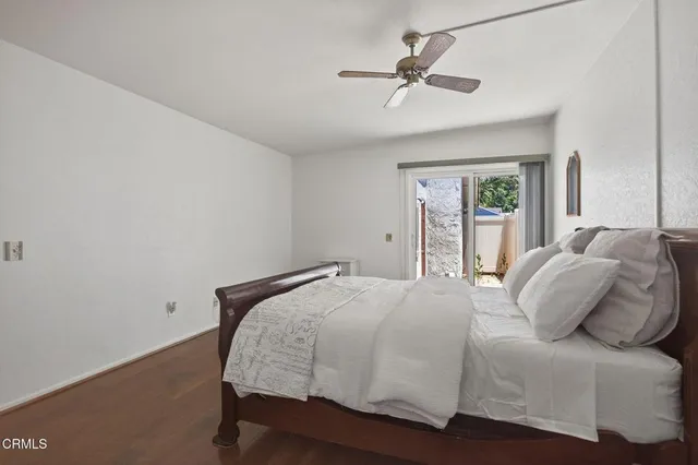 a bedroom with a large bed window and a ceiling fan