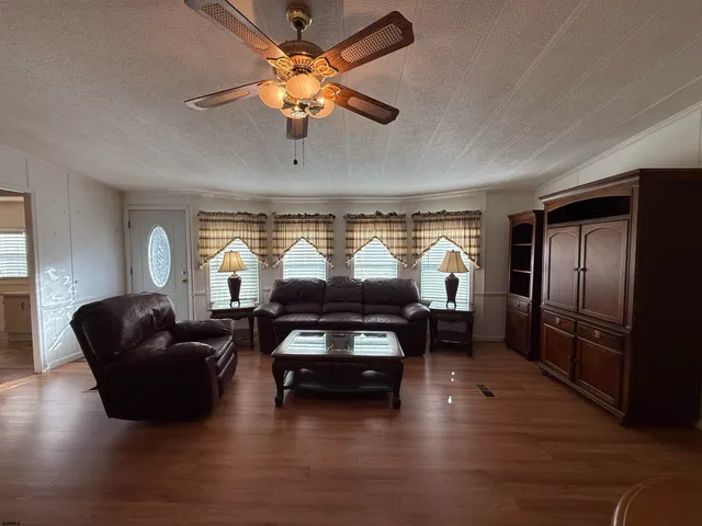 a living room with furniture a chandelier a fireplace and a flat screen tv