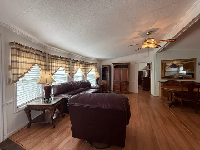 a living room with furniture a ceiling fan and a window
