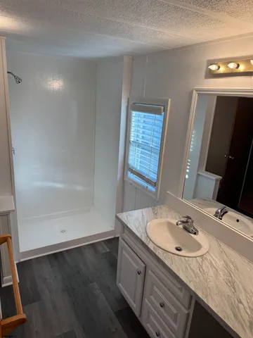 a bathroom with a sink a vanity a mirror and a bathtub