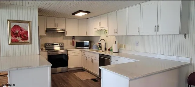 a kitchen with cabinets appliances and a counter space