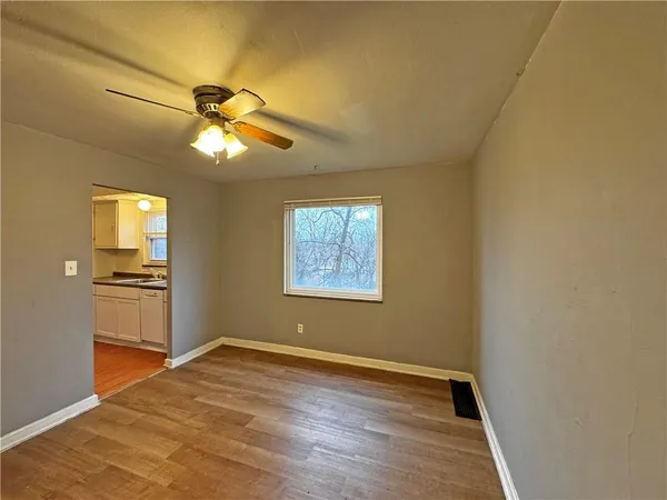 a view of empty room with wooden floor