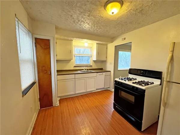 a kitchen with stove and white cabinets