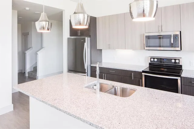 a kitchen with stainless steel appliances kitchen island sink refrigerator and stove