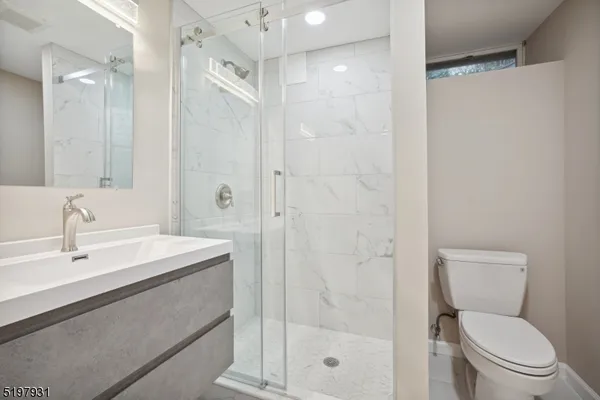 a bathroom with a shower a toilet sink and a mirror