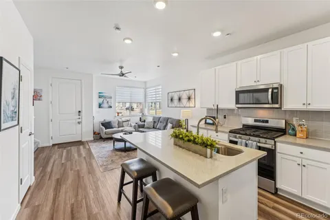 a kitchen with stainless steel appliances a table chairs microwave and refrigerator