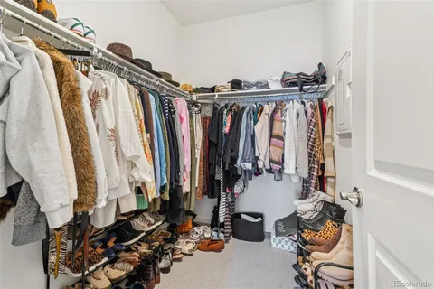 a view of walk in closet with clothes and shoes