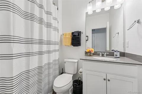 a bathroom with a sink a toilet a mirror and shower
