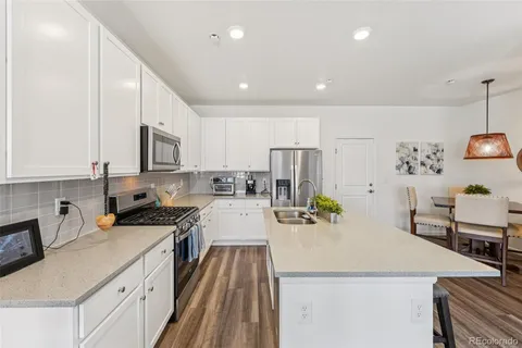 a kitchen with a sink a stove and chairs