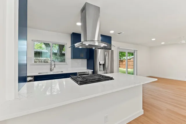 a kitchen with stainless steel appliances granite countertop a stove a sink and a refrigerator
