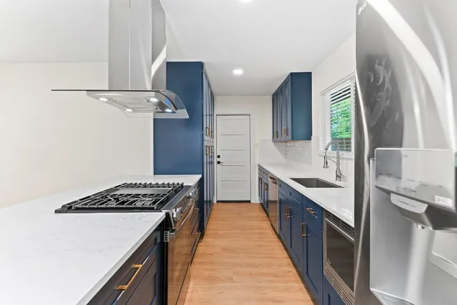 a kitchen with stainless steel appliances granite countertop a sink stove and refrigerator
