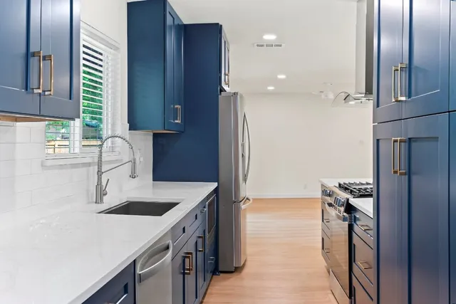 a kitchen that has a sink stainless steel appliances a counter space and a window