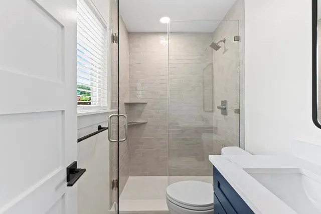 a bathroom with a sink a toilet and shower