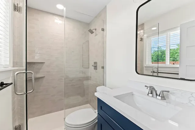 a bathroom with a sink a toilet and shower