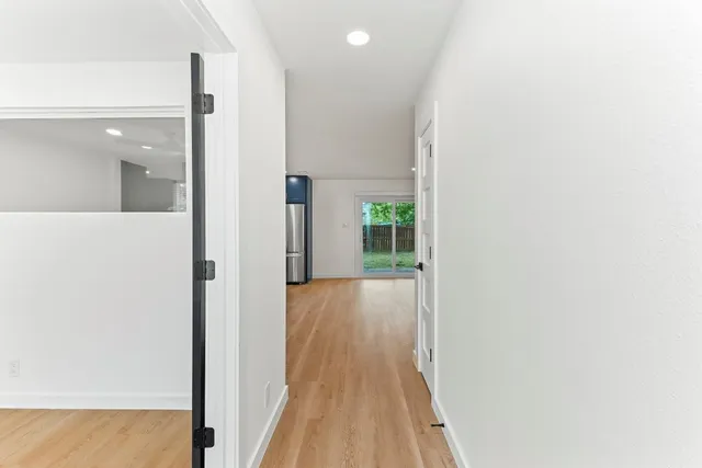 a view of a hallway with wooden floor