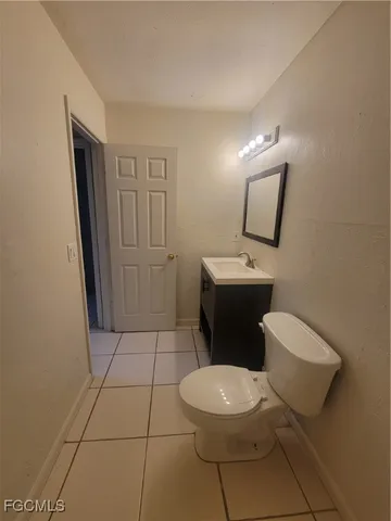 a white toilet sitting next to a bathroom sink and a mirror