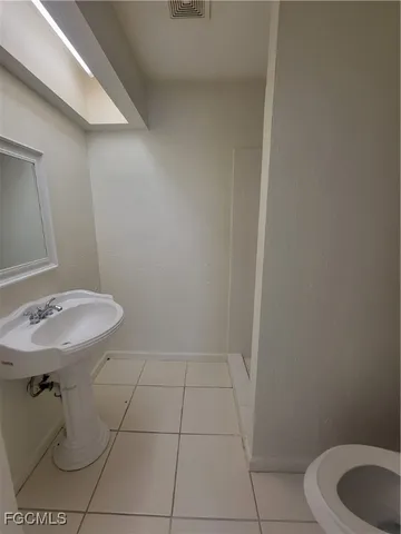a bathroom with a sink a toilet and a mirror